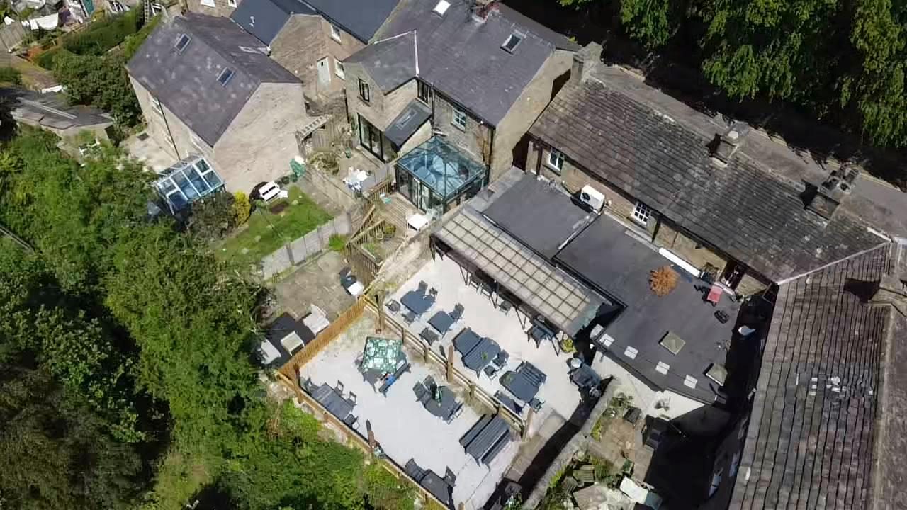 The beer garden at The Poachers Inn from above, tables and benches out in full sun